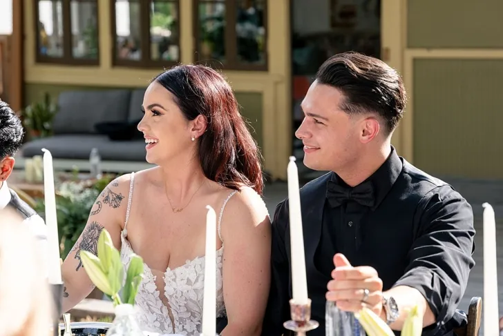 bride and groom smiling and listening to toast