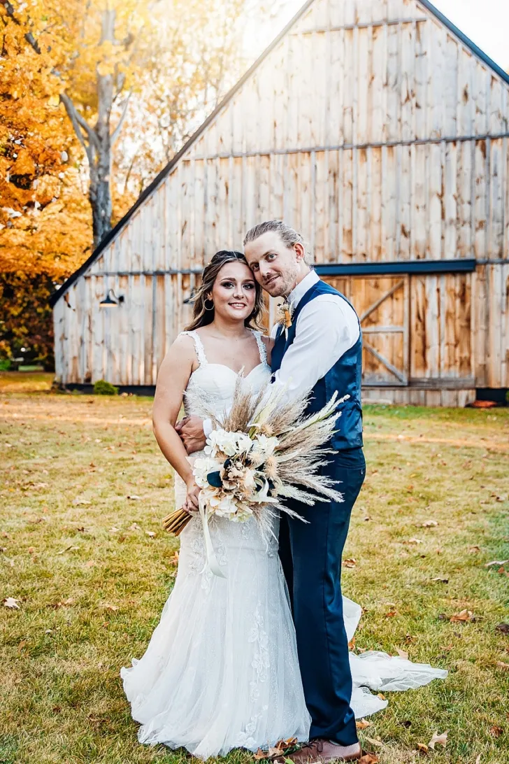 bride and groom embracing outside of wedding barn