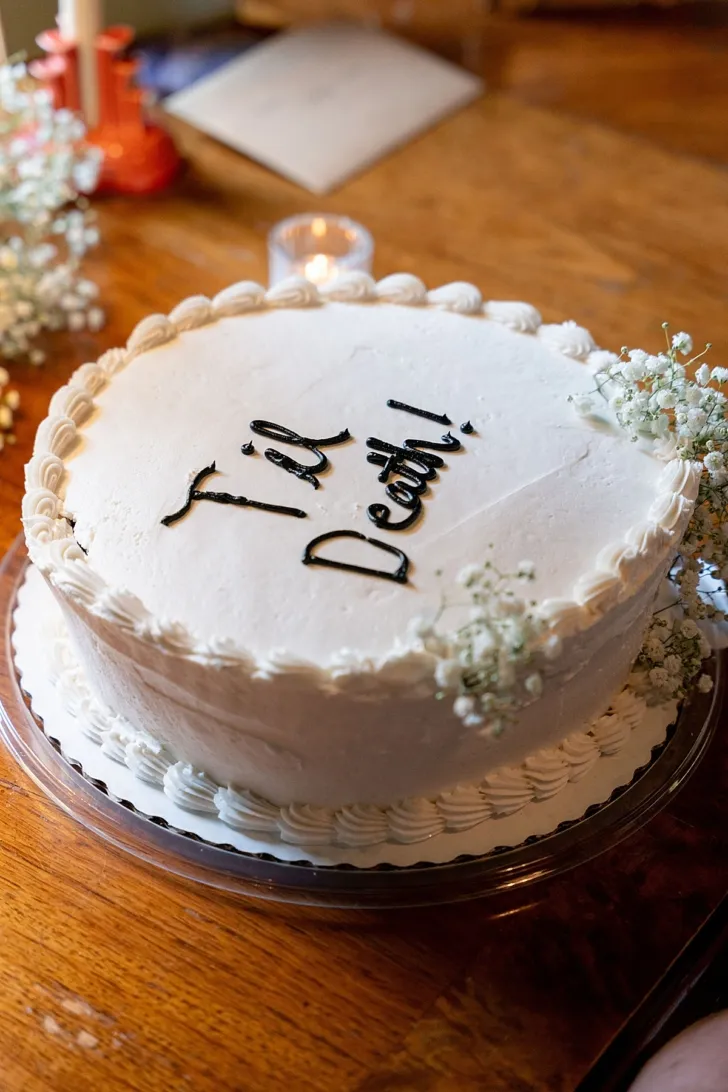 White wedding cake with Til Death! written on it