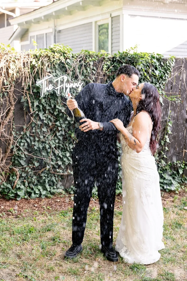 bride and groom popping champagne